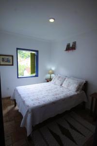 1 dormitorio con cama y ventana en Casazul - OP en Ouro Preto