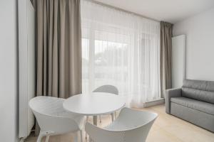 a white table and chairs in a living room at Aquamarina Prima 07 Seaside Studio by the BEACH with Terrace by Renters in Międzyzdroje