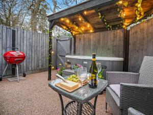 a patio with a table with a bottle of wine and grapes at 1 Bed in Christchurch 54900 in Ringwood