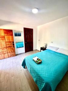 ein Schlafzimmer mit einem blauen Bett und einem Tablett darauf in der Unterkunft Mayara Hostal in El Zonte