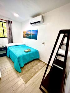 Schlafzimmer mit einem Bett mit blauem Laken in der Unterkunft Mayara Hostal in El Zonte