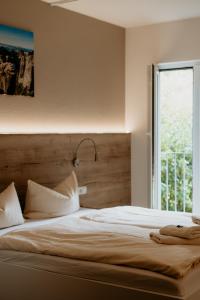 Schlafzimmer mit einem großen weißen Bett und einem Fenster in der Unterkunft Bergpension Laasen Perle Rathen in Kurort Rathen