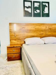- une chambre avec un lit et une tête de lit en bois dans l'établissement StarHomes, Jinja, à Jinja