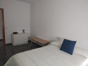 a bedroom with a bed with a blue pillow on it at CORTIJO DEL LUCERO, FERNAN PEREZ in Almería