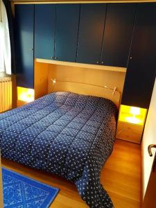 een slaapkamer met een bed met een blauw dekbed bij Casa Dolce Presena in Passo del Tonale