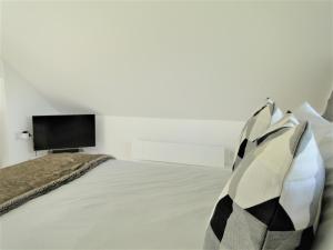 a bedroom with a bed with a tv on the wall at Cober House in Helston