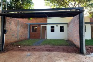 uma garagem vazia com uma parede de tijolos em Hermosa casa, zona Aeropuerto em Luque