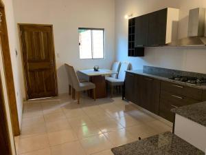 a kitchen with a table and a dining room at Hermosa casa, zona Aeropuerto in Luque