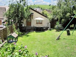 ogród ze stołem i parasolem w obiekcie Maison enchanteresse à Ingersheim avec vue sur la montagne w mieście Ingersheim