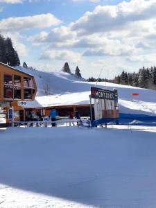 pokryty śniegiem budynek z znakiem przed nim w obiekcie Maison enchanteresse à Ingersheim avec vue sur la montagne w mieście Ingersheim
