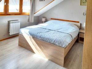 łóżko z drewnianą ramą w sypialni w obiekcie Maison enchanteresse à Ingersheim avec vue sur la montagne w mieście Ingersheim