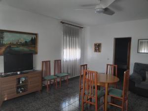un soggiorno con tavolo, sedie e TV di CORTIJO DEL LUCERO, FERNAN PEREZ a Almería