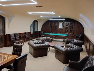 a room with leather chairs and a pool table at Boutique Hotel Gaia in Kecskemét