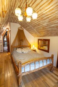 a bedroom with a large bed with a wooden ceiling at Fortuna Eco - Boutique Hotel in Băile Tuşnad