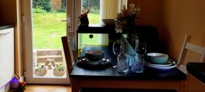 a kitchen counter with a table with plates and glasses at Pine Cottage in Streatham