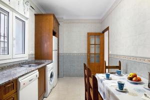 cocina con mesa, fregadero y nevera en Aptº Jábega, Familias y Parejas, en Conil de la Frontera 12 fotos más