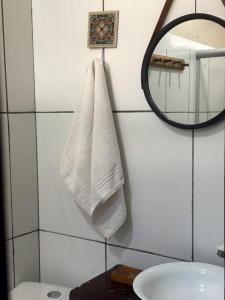 a bathroom with a white towel hanging on a wall at Casa di Vó in Mucugê