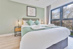 a bedroom with a large white bed with a window at Stylish 2 Bed Apartment Nightingale Quarter Derby in Derby