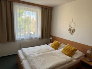 una camera da letto con un letto con cuscini gialli e una finestra di Apartmány KiRi a Kyjov