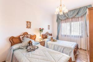 1 dormitorio con 2 camas individuales y lámpara de araña en Casa Venta Ruizo, en Lorca
