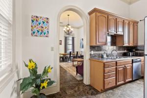 a kitchen with an archway leading into a dining room at 3BD HOME STEPS TO SAINT CHARLES Gated Parking in New Orleans