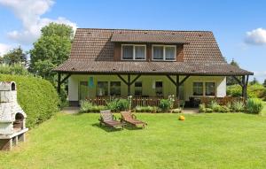 a house with two benches in the yard at Cozy Apartment In Blankensee With Kitchen in Blankensee