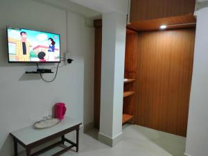 sala de estar con TV en la pared en Gyatso Guest House en Tawang