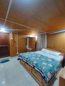 1 dormitorio con 1 cama grande en un barco en Gyatso Guest House en Tawang
