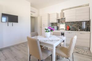 cocina y comedor con mesa blanca y sillas en Villa Arjana, en Camemi