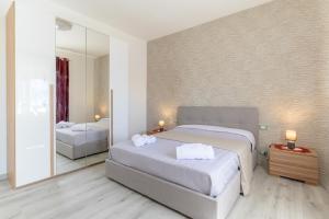 1 dormitorio con 2 camas y espejo en Villa Arjana, en Camemi