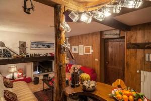 un soggiorno con pannelli in legno e una camera con tavolo di Modest & Cheap Tavern for a Spartan Retreat a Courmayeur