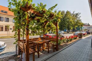 a wooden gazebo with a table and some flowers at Apartmány KiRi in Kyjov