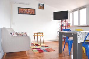 a living room with a table and a chair at Je jazz les couleurs à Albi - Centre Unesco - Parking - Climatisation - Animaux acceptés in Albi