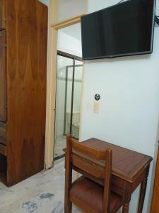 una mesa de madera con una silla de madera junto a una puerta en HOTEL EJECUTIVO, en Pitalito