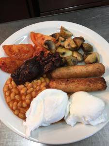 a plate of food with eggs beans and tomatoes at The Farm Burscough in Burscough