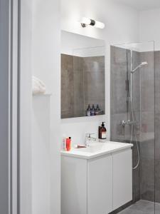 a white bathroom with a sink and a shower at BRIK Apartment Hotel in Copenhagen