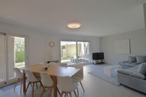 a dining room and living room with a table and chairs at Pretty terraced house with garden level and garage in Aix-les-Bains