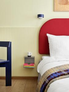 a bedroom with a bed and a red headboard at BRIK Apartment Hotel in Copenhagen