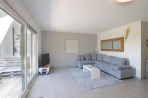a living room with a couch and a tv at Pretty terraced house with garden level and garage in Aix-les-Bains