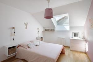 ein weißes Schlafzimmer mit einem Bett und einem Fenster in der Unterkunft Pretty terraced house with garden level and garage in Aix-les-Bains