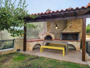 un patio con mesa de picnic y horno de pizza en Agnanti Despoina villa with private pool, en Skouloúfia