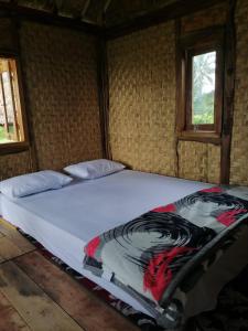 a large bed with a picture of a woman on it at Padi Bungalows in Tetebatu