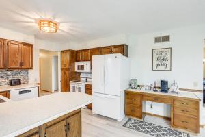 Una cocina con refrigerador blanco y gabinetes de madera. en Quiet Greenwich Home with Pool and Screened Porch!, en Greenwich