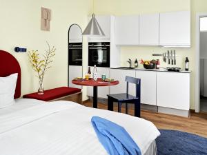 a bedroom with a bed and a small kitchen at BRIK Apartment Hotel in Copenhagen
