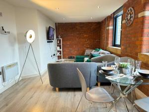 ein Wohnzimmer mit einem Sofa und einem Tisch in der Unterkunft Stunning 2 Bed Apartment In Bradford City Centre With Free Parking in Bradford