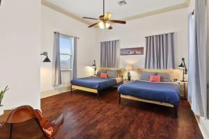 ニューオーリンズにある3BD HOME STEPS TO SAINT CHARLES Gated Parkingのベッド2台と天井ファン付きの寝室
