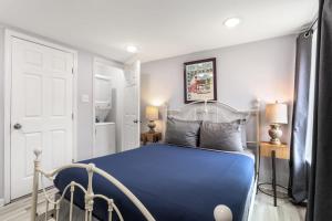 1 dormitorio con cama azul y puerta blanca en Skip to Saint Charles Local Art-Filled Hideaway, en Nueva Orleans