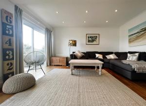 ein Wohnzimmer mit einem schwarzen Sofa und einem Tisch in der Unterkunft North Quay in Saint Helens