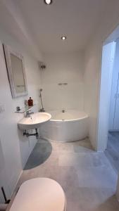 een badkamer met een bad, een wastafel en een toilet bij Apartment am Waldbach in Gernsbach