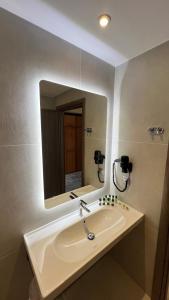 a bathroom with a sink and a mirror at Sunset Hotel in Ouranoupoli